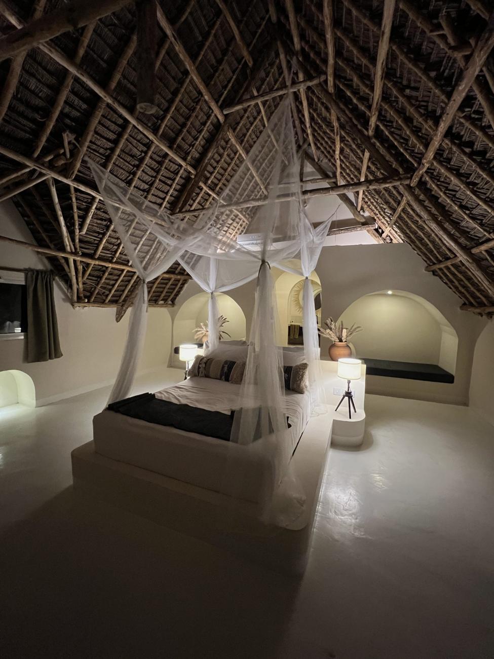 The apartment with a four-poster bed under a thatched roof
